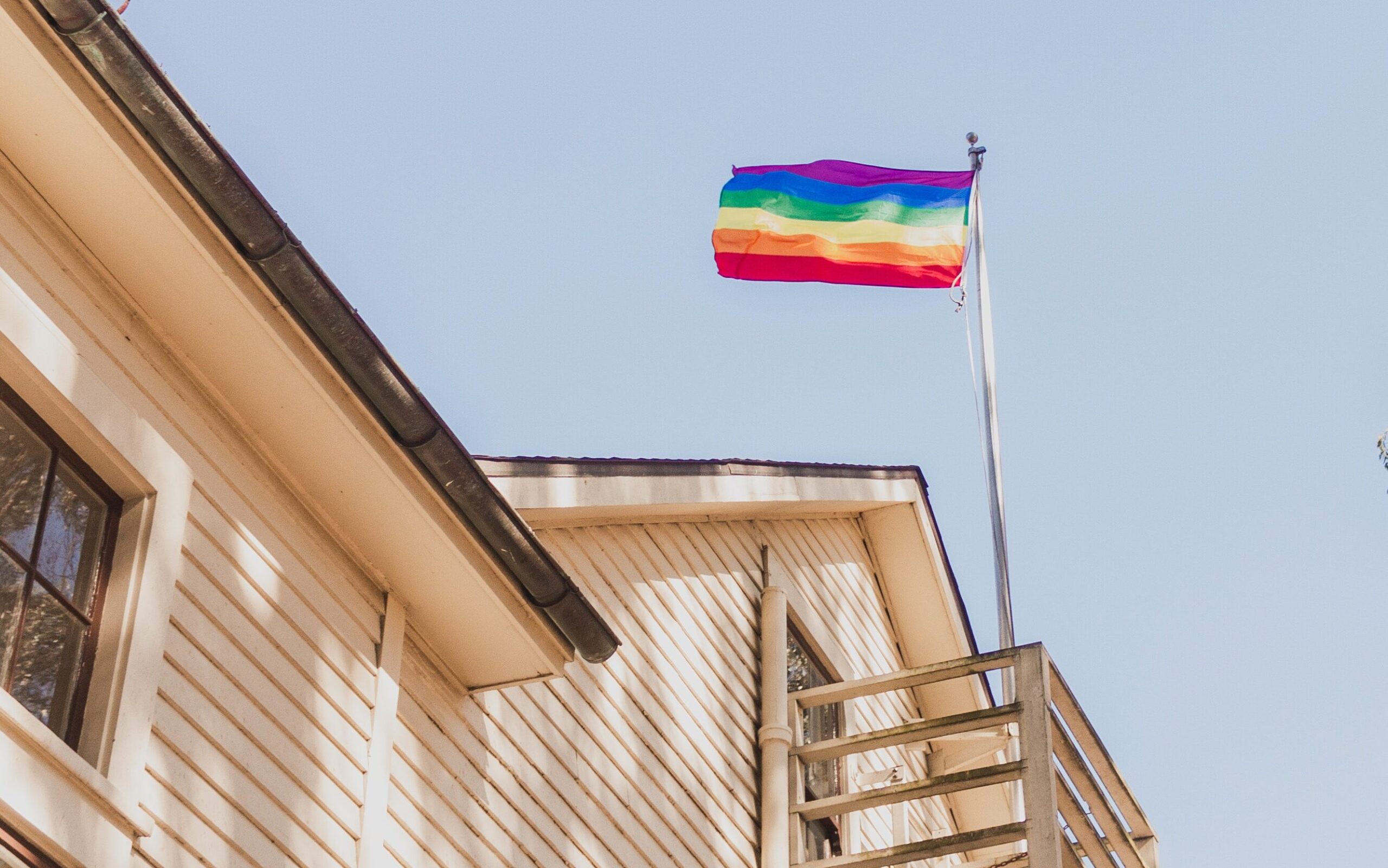 Decorative. A pride flag flies at the top of a house.