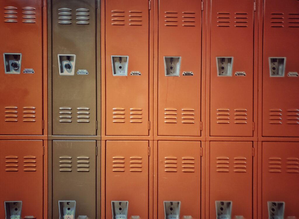 Decorative. A wall lined with orange half lockers has two olive lockers.